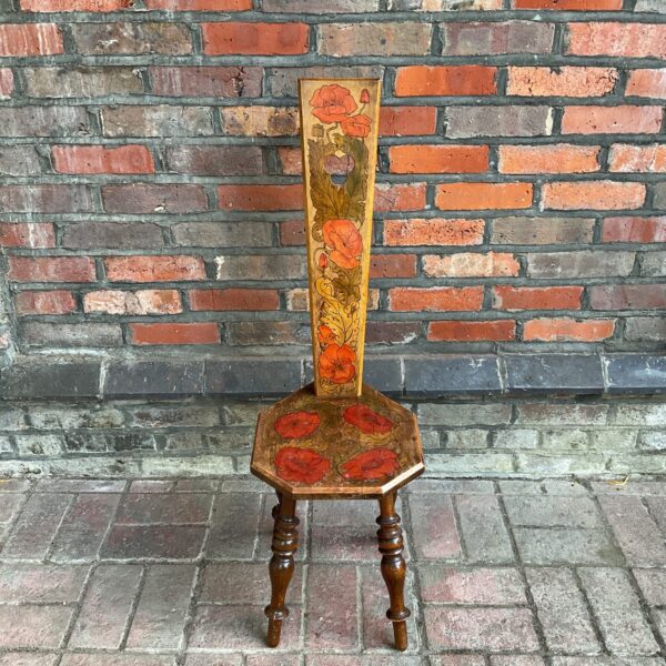Antique Victorian spinning chair with vibrant poppy pattern.