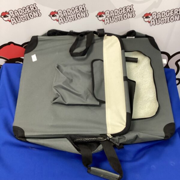Side view of a grey folding dog carrier with handles.
