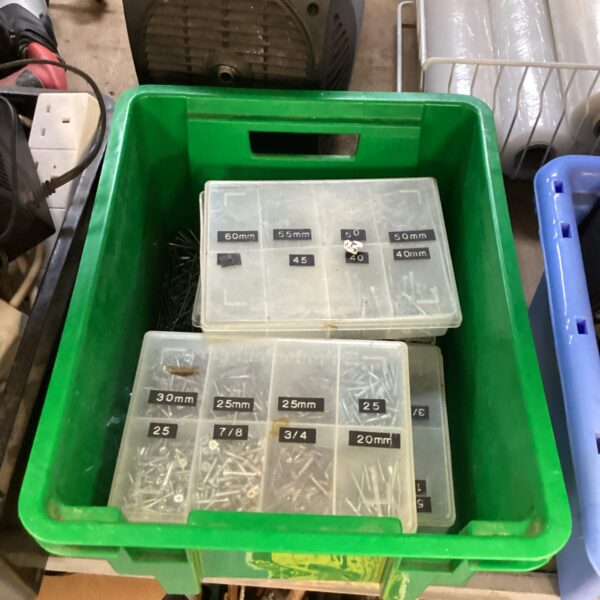 Mixed lot of screws and nails in a green container.
