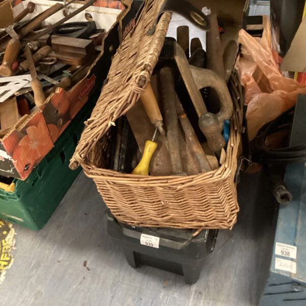 Woven basket filled with a mixed lot of vintage hand tools.