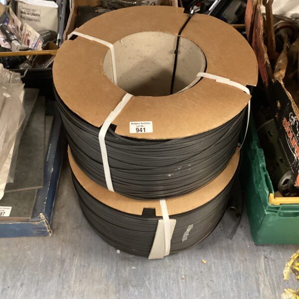 Two reels of black plastic packaging banding for industrial use.