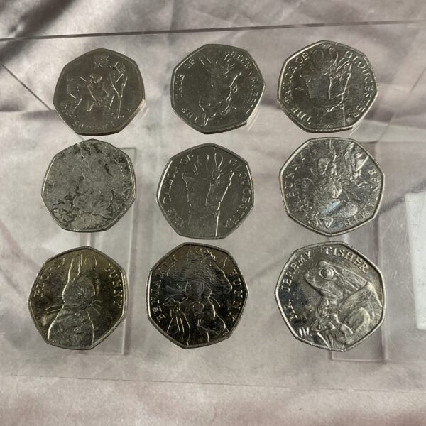 Lot of nine Beatrix Potter 50p coins including Peter Rabbit and Olympic coin.
