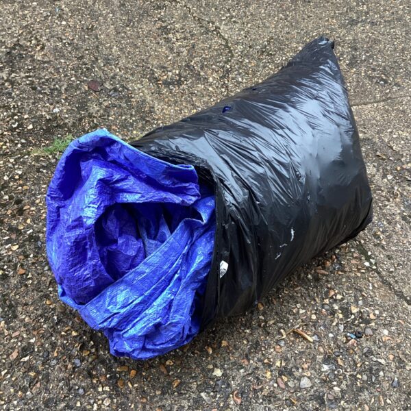 Rolled blue tarpaulin, large waterproof cover for outdoor use.