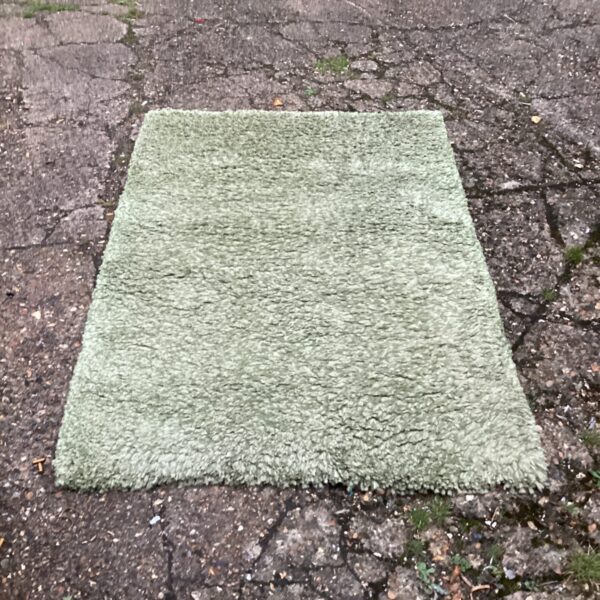 Vintage green shag pile rug with deep texture.