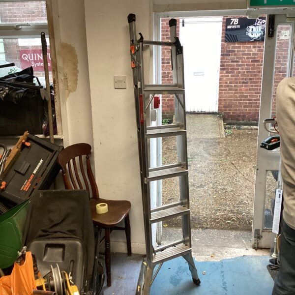 Aluminium five-rung step ladder in a workshop setting.