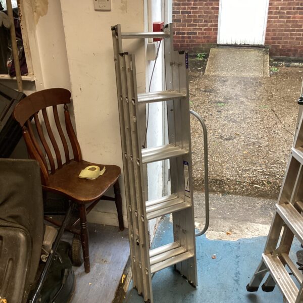 Aluminium loft ladder leaning against a wall, for attic access.