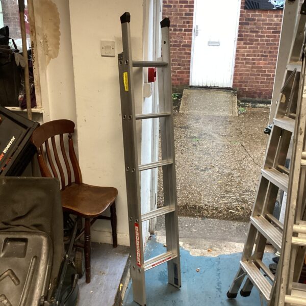 Silver aluminium loft ladder leaning against a wall.