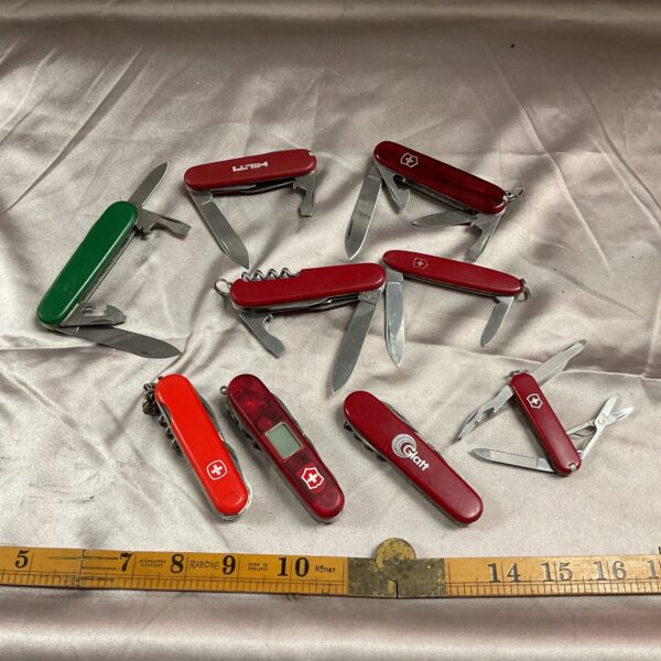 Group of nine Victorinox Swiss Army Knives, multi-tool collection.