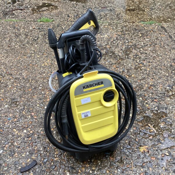 Yellow and black Karcher K5 compact pressure washer for garden cleaning.