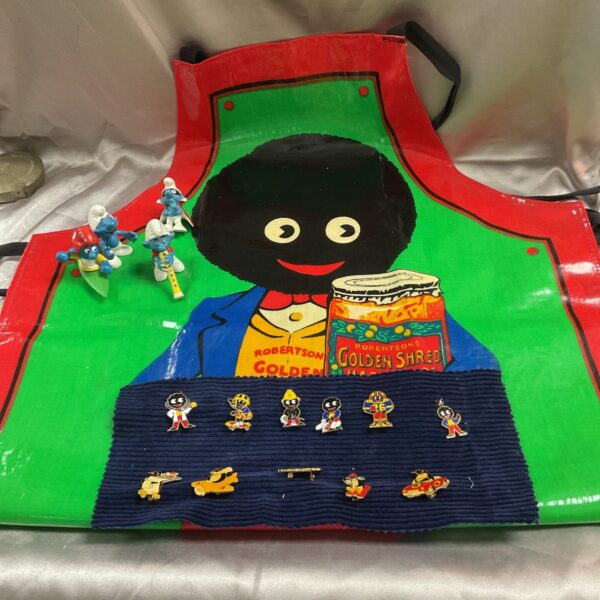 Vintage Robertson's Golly apron with badges displayed, collectible advertising.