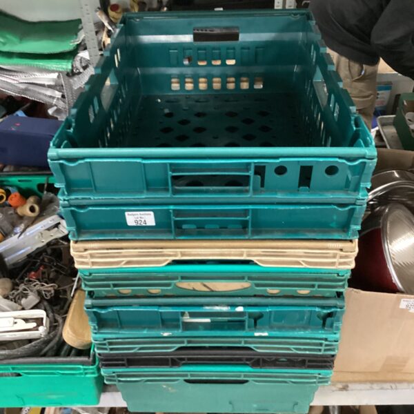 Stack of eight green plastic fruit crates for storage.