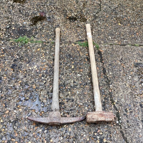 Vintage pickaxe and sledgehammer set showing signs of age and use.