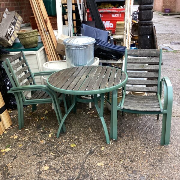 Vintage metal and wood garden table and chairs set in a garden.