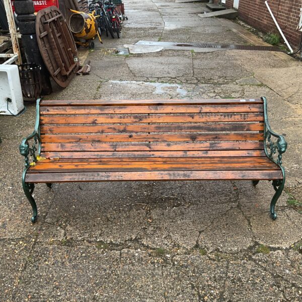 Antique wrought iron garden bench in a garden setting.