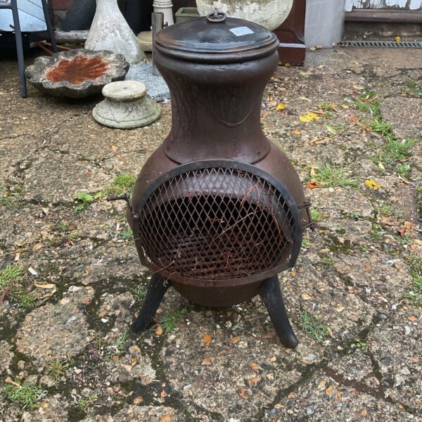 Antique iron garden fire pit with openwork detailing.