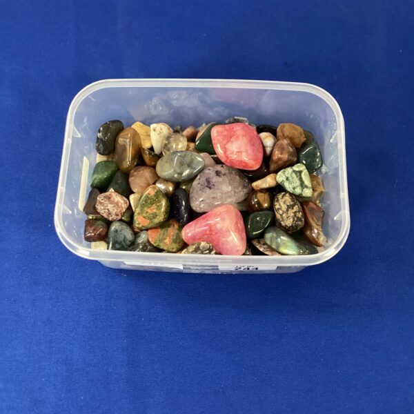 Collection of colourful polished stones in a plastic tub.