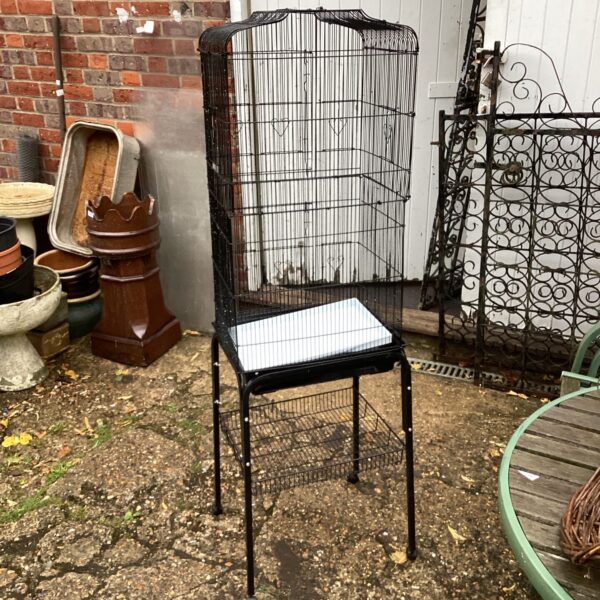 Large dark metal bird cage on wheels, suitable for pet birds.
