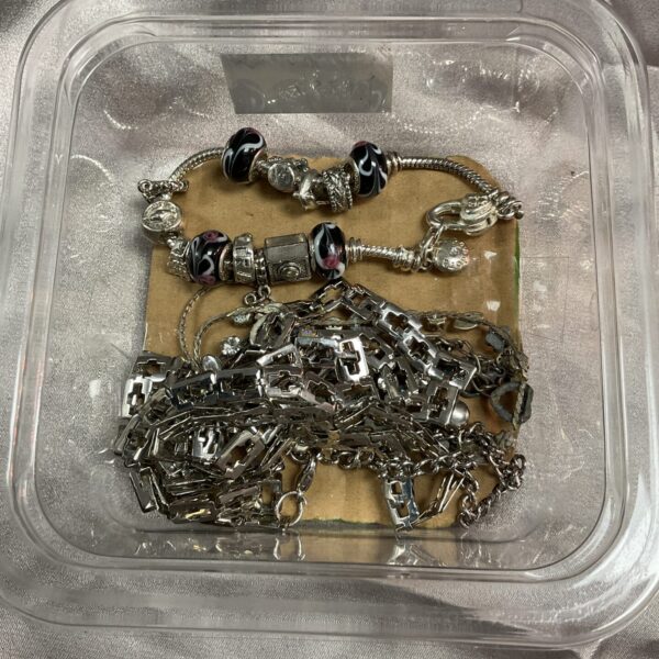 Silver Pandora bracelet with assorted charms in a jewellery lot.