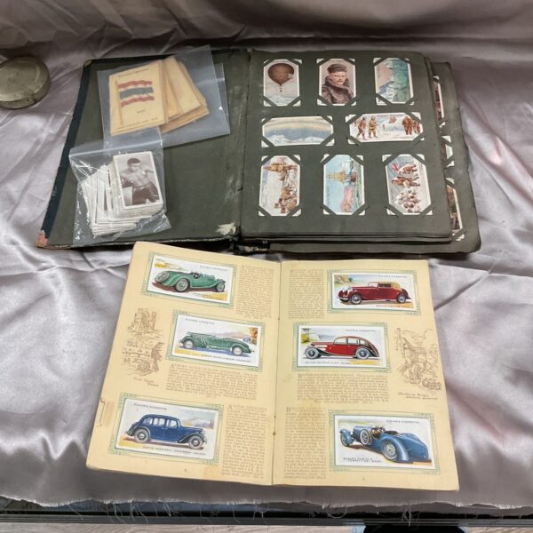 Vintage cigarette card albums featuring regimental uniforms and boxing cards.