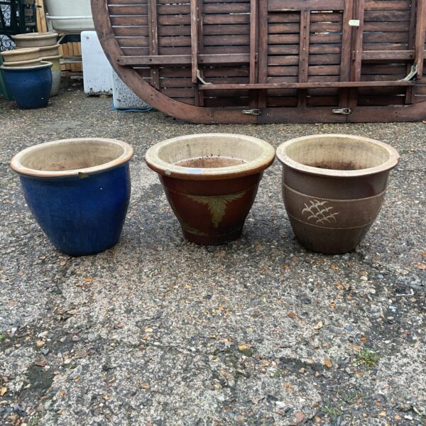 Lot of three vintage painted garden pots with floral designs.
