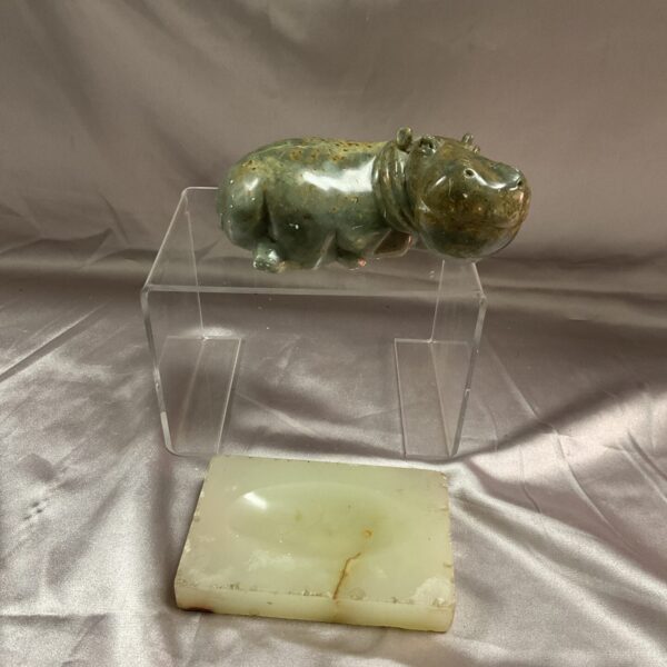Vintage marble hippopotamus figurine and dish on display.