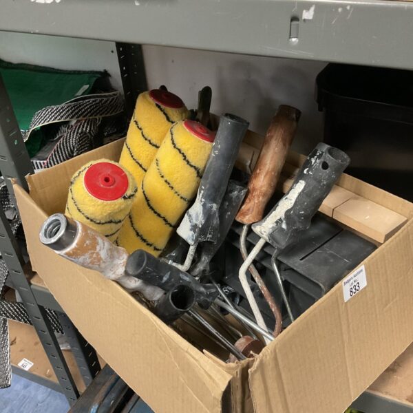 A box of used paint rollers and handles for DIY projects.