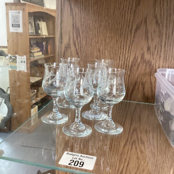 Set of six miniature cut glass port glasses on display.