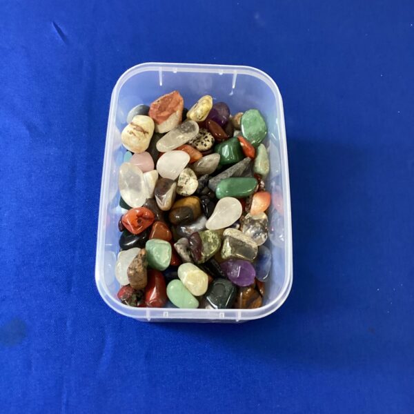 Colourful collection of polished stones in a plastic container.