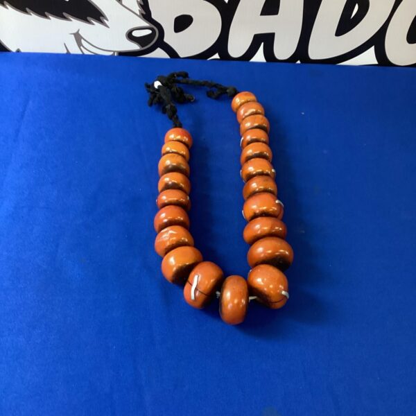 Close-up of a chunky African bead necklace with reddish-brown beads.