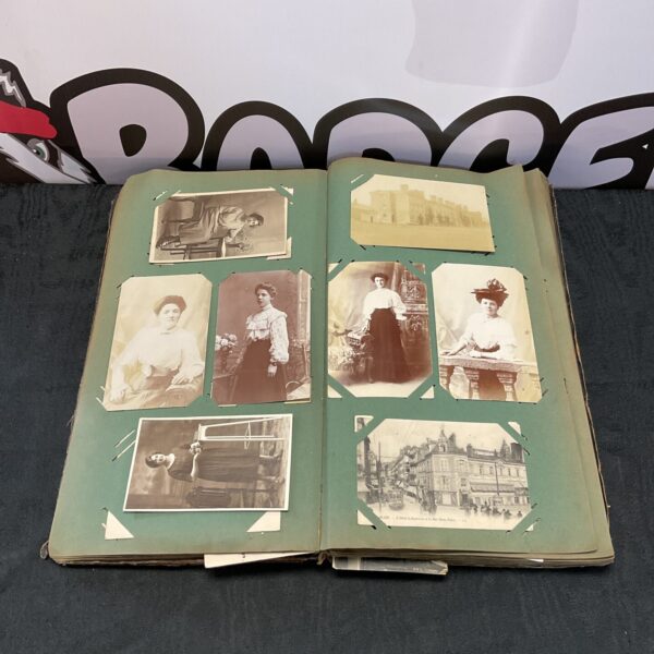 Victorian postcard album open to a page with multiple vintage photos and cards.