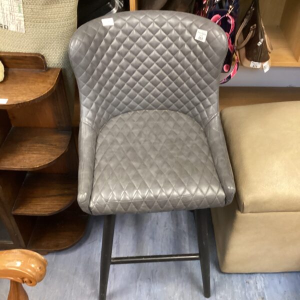 Grey Dunelm leather stool with quilted seat and wooden legs.