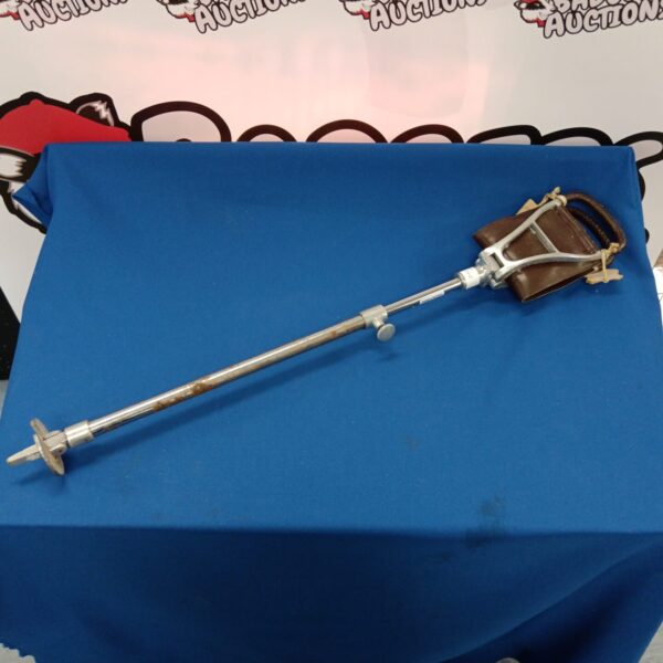 Vintage shooting stick with leather seat and tripod base.