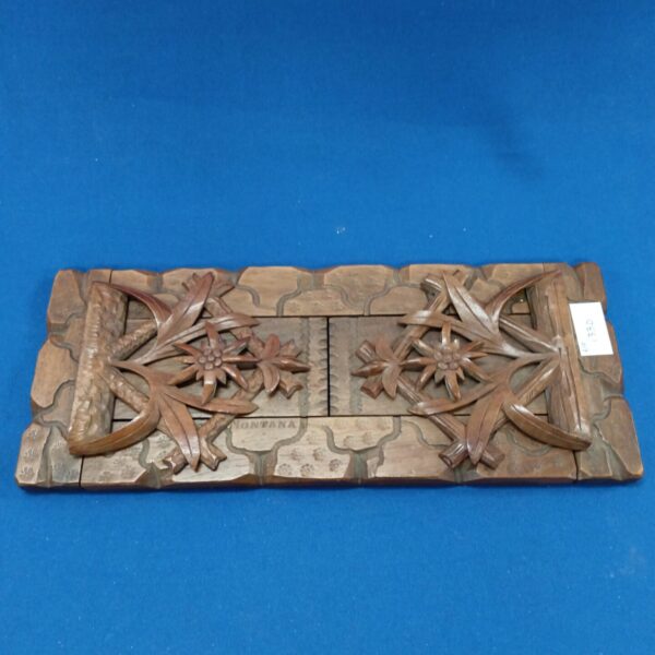 Front view of vintage Montana carved bookshelf with floral and antler design.