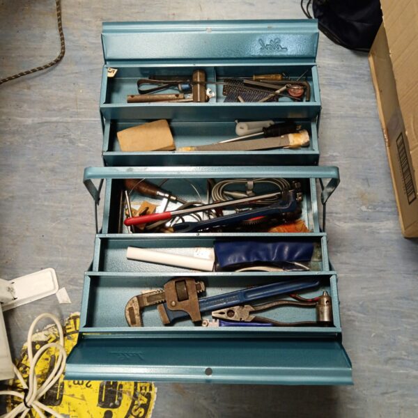 Vintage blue metal tool box filled with various tools.