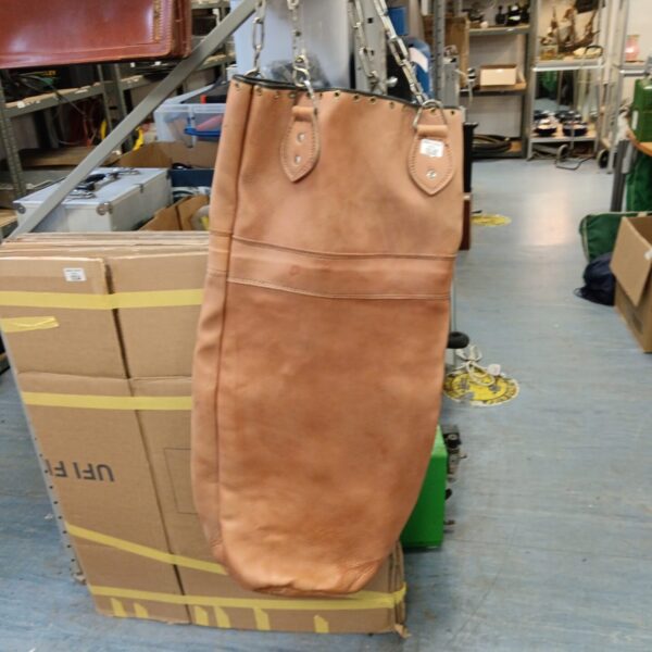 Vintage pigskin boxing punch bag with hanging chains.