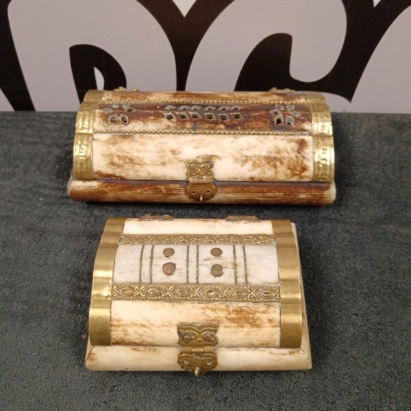 Pair of vintage bone trinket boxes with carved details.