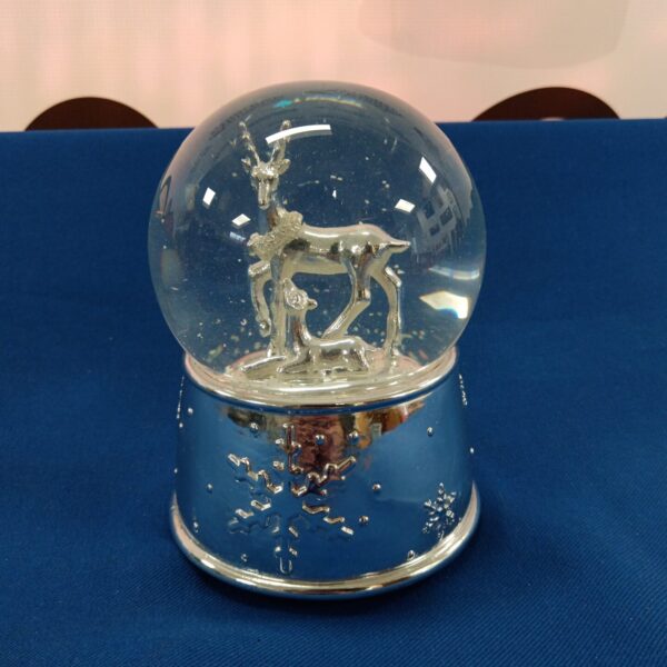 Vintage Christmas snow globe with deer figures inside.
