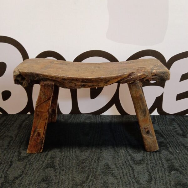 Antique 18th-century gout stool with three legs, rustic and weathered.