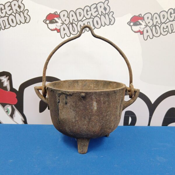 Small antique cast iron cauldron with a rustic patina.