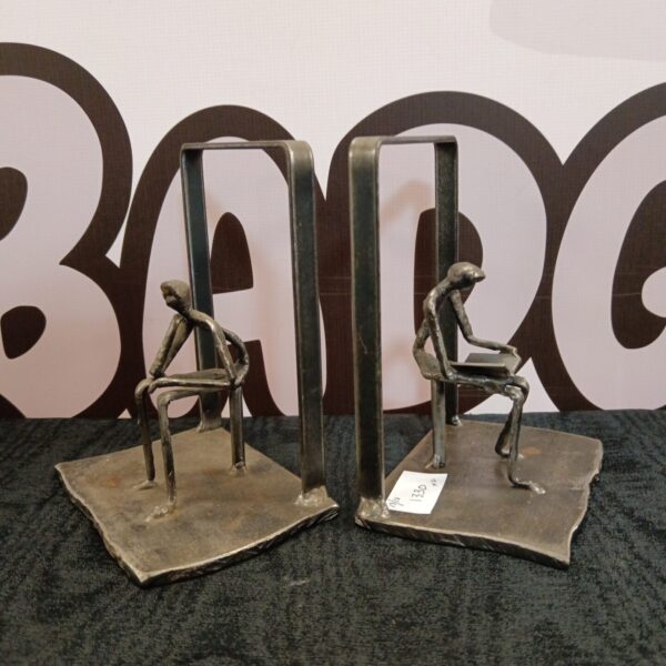 Vintage cast iron bookends featuring a thinking man sculpture.
