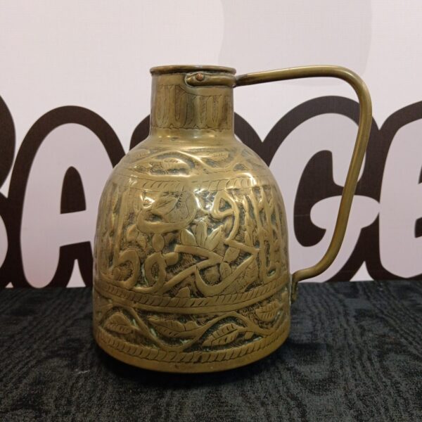 Intricate antique Mughal brass jug with calligraphy details.