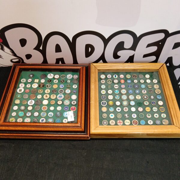Framed collection of diverse golf ball markers for collectors.