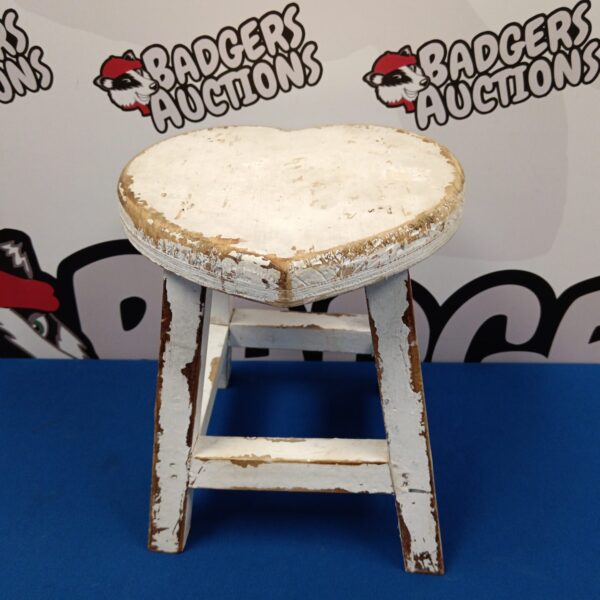 Vintage heart-shaped milking stool with weathered wood finish.