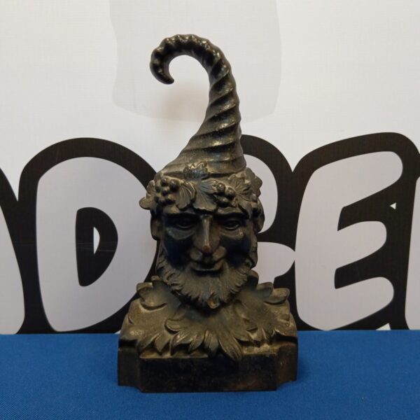 Antique cast iron Green Man doorstop with detailed foliage.