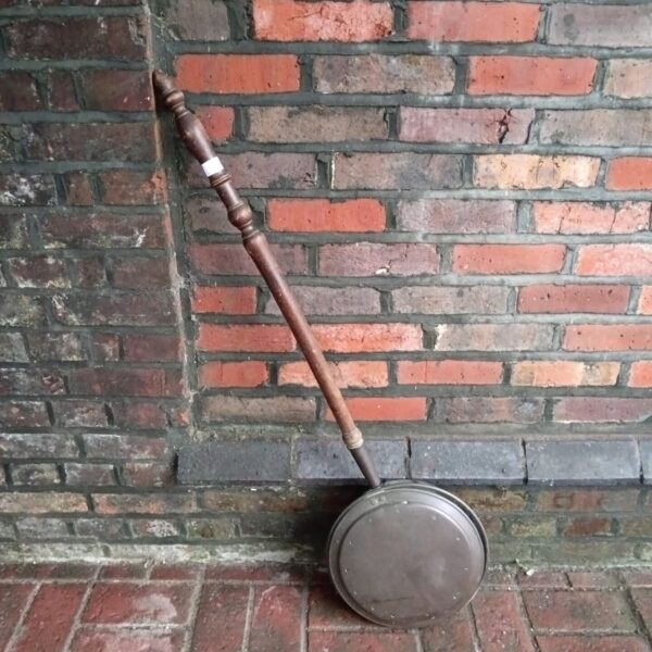 Antique copper bed pan with wooden handle, vintage medical collectible.