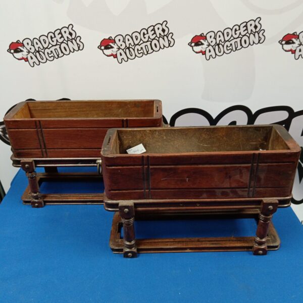 Pair of antique oak trough planters on stands for garden display.