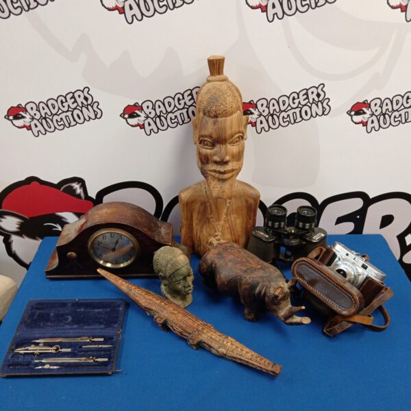 Mixed lot of African carvings, vintage binoculars, and a mantle clock.
