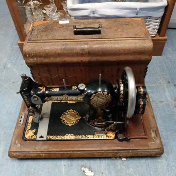 Antique Jones hand crank sewing machine in wooden case.