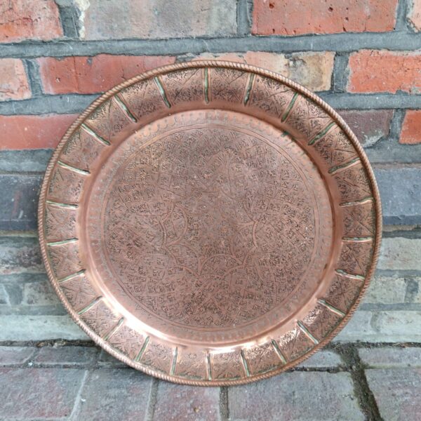 Intricate vintage Persian copper tray with detailed hand-hammered design.