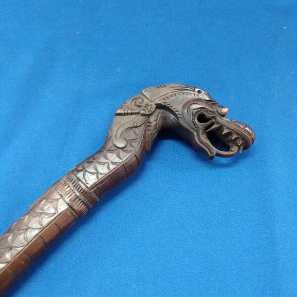 Detailed head of a hand-carved Indonesian dragon walking stick.